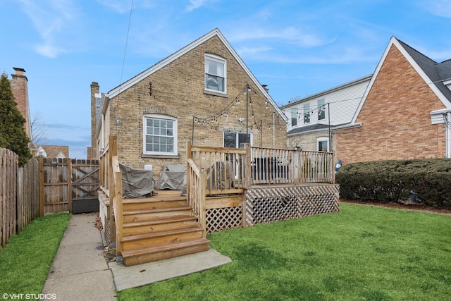 rear view of house with brick siding, a yard, a gate, fence, and a wooden deck