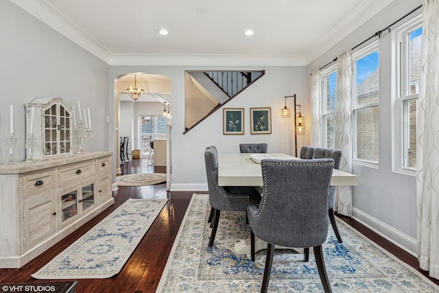 dining space with a wealth of natural light, baseboards, arched walkways, and crown molding