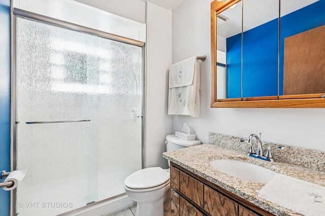 bathroom with toilet, a shower stall, and vanity