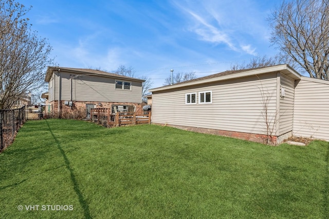 rear view of house featuring a lawn, a wooden deck, and fence