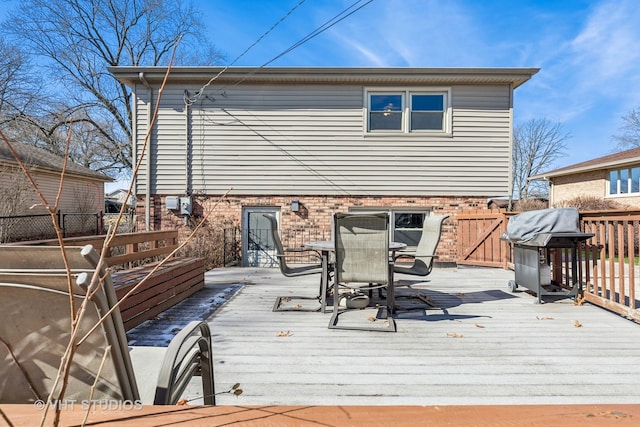 wooden deck featuring outdoor dining area, fence, and grilling area