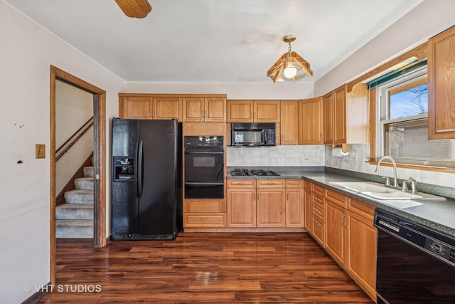 kitchen with decorative backsplash, dark wood-type flooring, black appliances, a sink, and a warming drawer