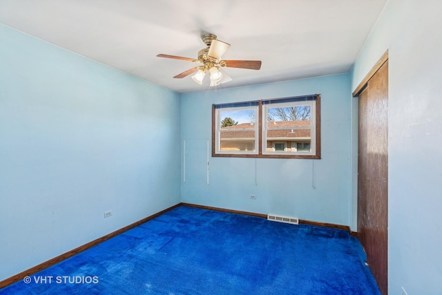 spare room featuring a ceiling fan, baseboards, visible vents, and carpet flooring