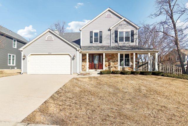 front facade with a porch, a garage, and a front lawn