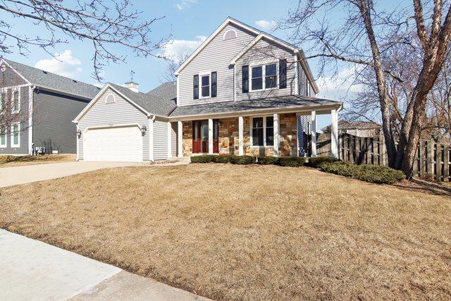 view of front of property featuring a garage, a front lawn, and covered porch