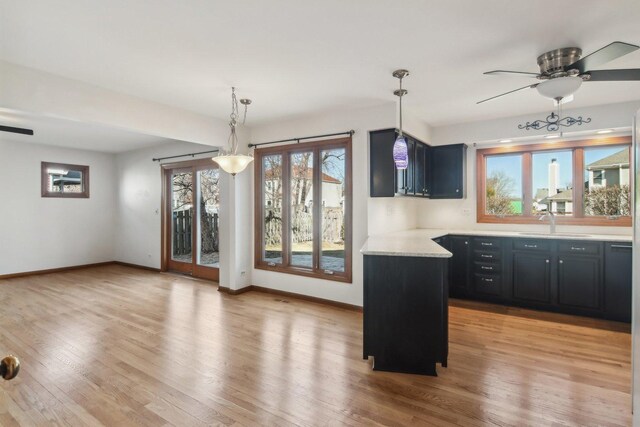 kitchen with pendant lighting, light hardwood / wood-style flooring, and a wealth of natural light