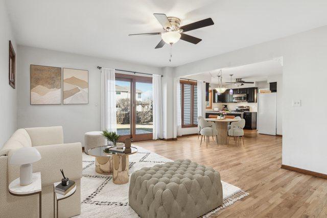 living room featuring ceiling fan and light wood-type flooring