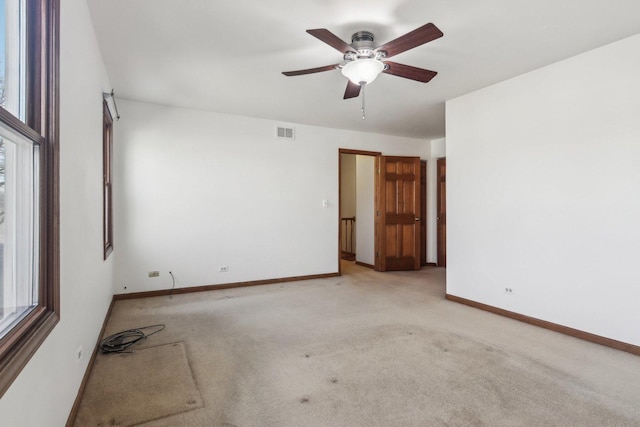 carpeted empty room with plenty of natural light and ceiling fan