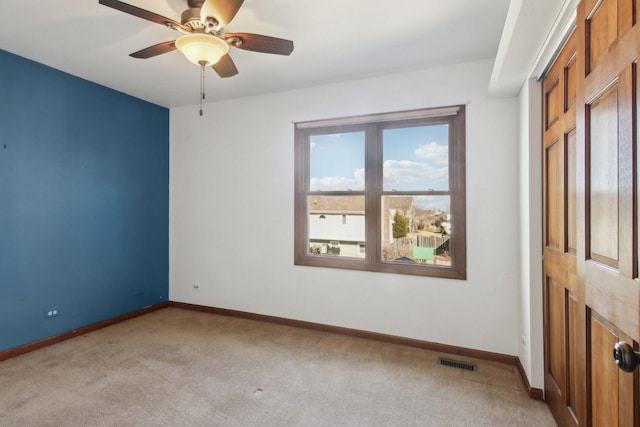 carpeted spare room featuring ceiling fan