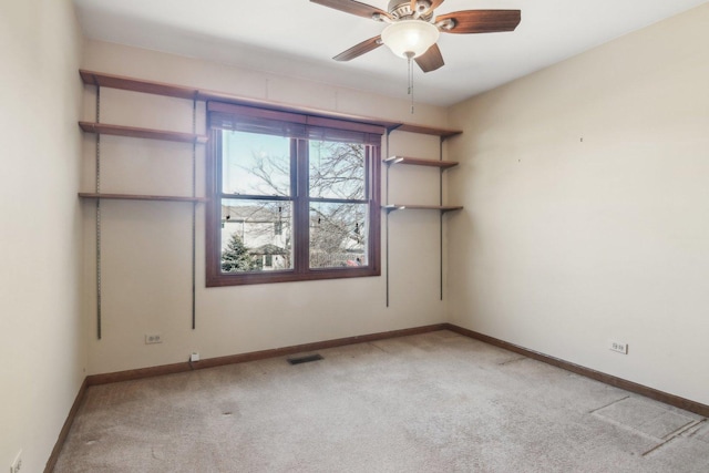 empty room featuring ceiling fan and light colored carpet