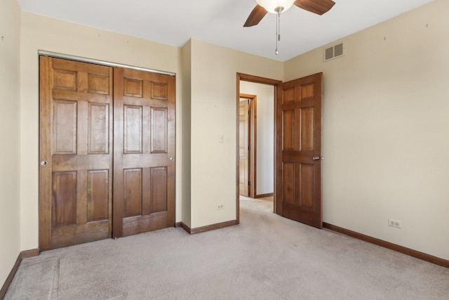 unfurnished bedroom with ceiling fan, a closet, and light carpet