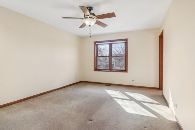 empty room featuring light colored carpet and ceiling fan