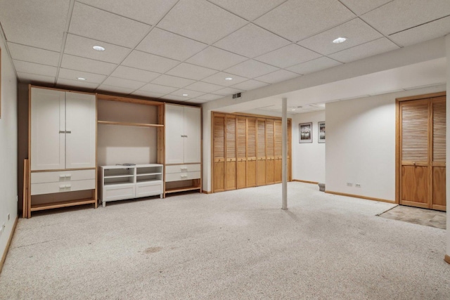 basement with light carpet and a drop ceiling