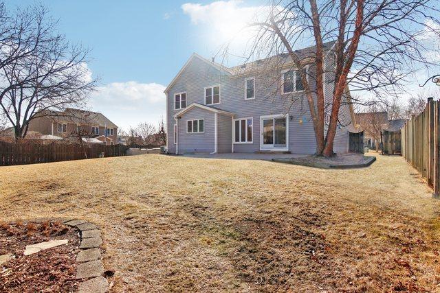 rear view of house featuring a lawn