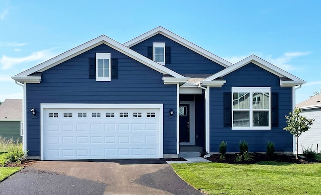 view of front of home with a garage and a front lawn