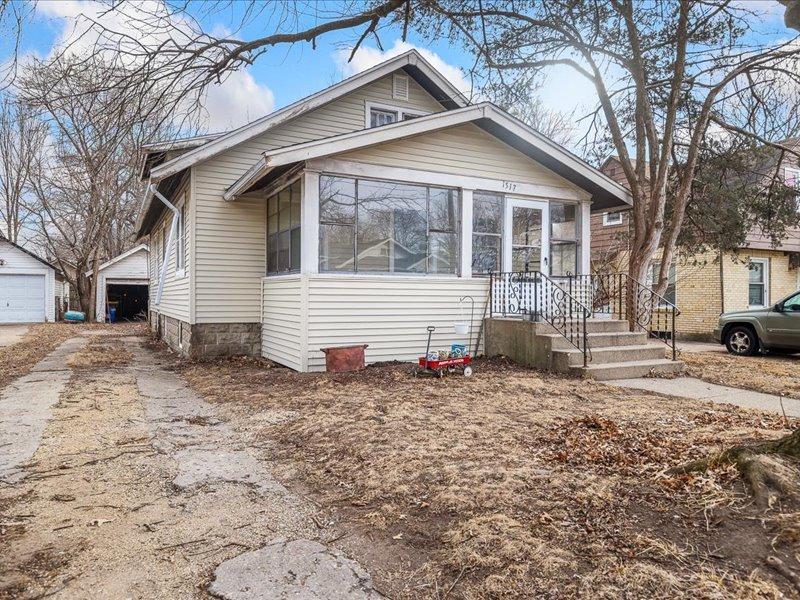 bungalow-style home with a garage and a sunroom