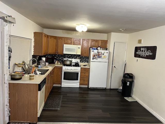 kitchen featuring tasteful backsplash, white appliances, dark hardwood / wood-style flooring, and sink