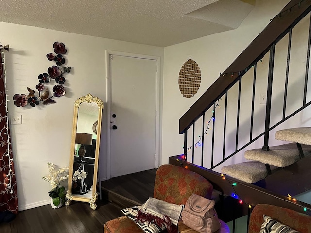 entryway with dark hardwood / wood-style floors and a textured ceiling