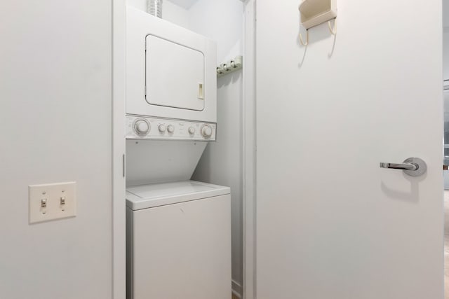 clothes washing area with stacked washer and clothes dryer