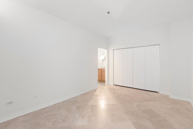 unfurnished bedroom featuring ensuite bathroom and a closet