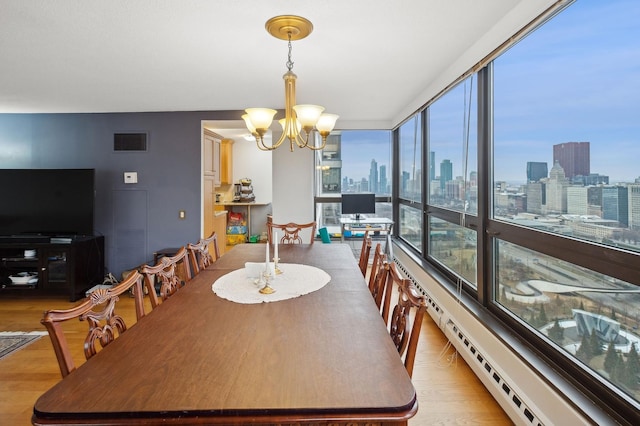 dining space featuring an inviting chandelier and light wood-type flooring