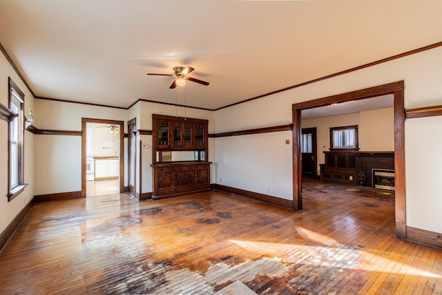 unfurnished living room featuring ornamental molding, a brick fireplace, ceiling fan, and dark hardwood / wood-style flooring