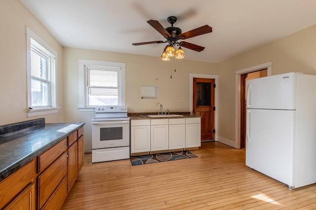 kitchen featuring sink, white appliances, light hardwood / wood-style flooring, and ceiling fan