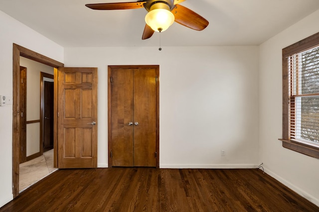 unfurnished bedroom featuring dark wood-type flooring and ceiling fan