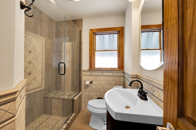 bathroom featuring an enclosed shower, vanity, tile walls, and toilet