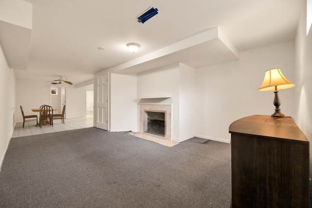 unfurnished living room with a high end fireplace, ceiling fan, and carpet