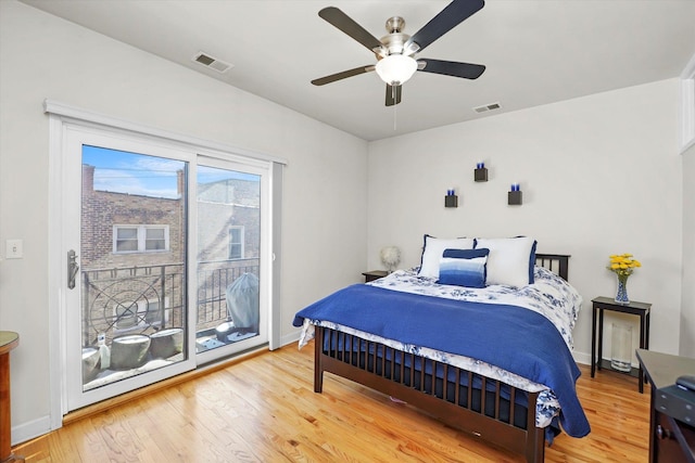 bedroom with access to exterior, baseboards, visible vents, and wood finished floors