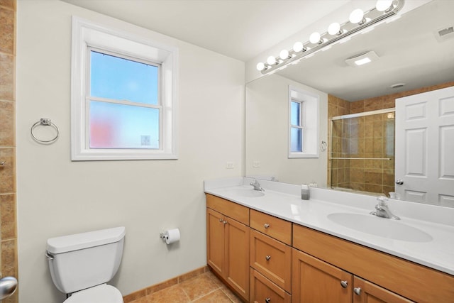 bathroom featuring toilet, a shower stall, a sink, and tile patterned floors