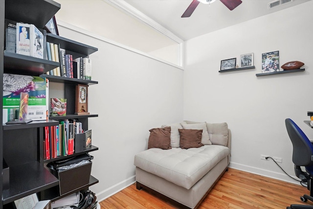 office area featuring baseboards, wood finished floors, visible vents, and a ceiling fan