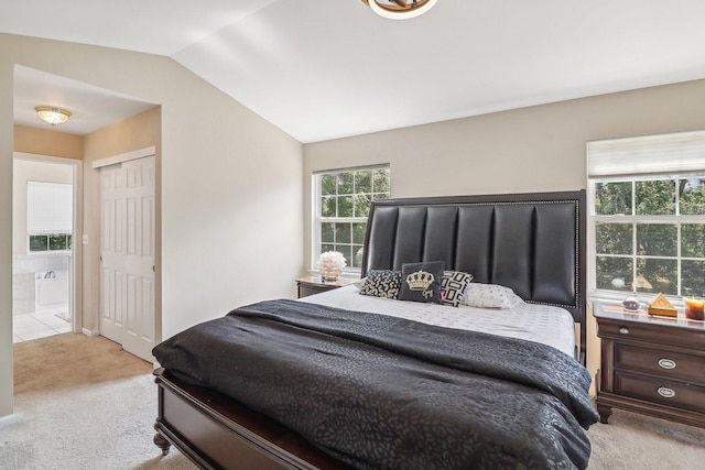 bedroom with lofted ceiling, light carpet, and a closet