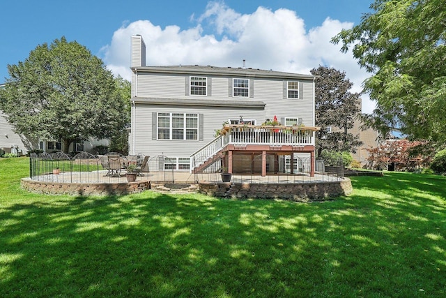 rear view of property with a wooden deck, a lawn, and a patio