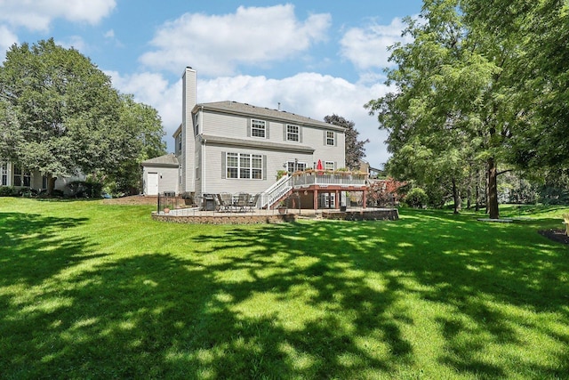 rear view of house with a patio, a yard, and a deck