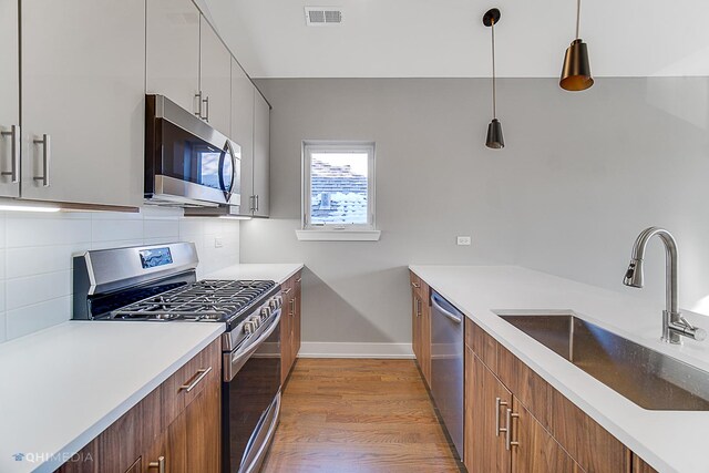 1734 W Cullerton St, Chicago, IL 60608 - kitchen with sink, white cabinetry, hanging light fixtures, backsplash, and stainless steel appliances