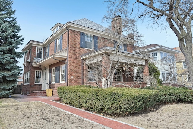 traditional style home featuring brick siding and a chimney