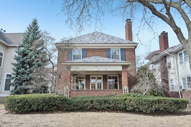 american foursquare style home with brick siding