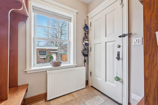 foyer featuring baseboards and radiator