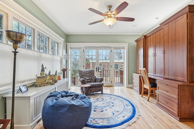 home office with light wood-style floors, french doors, built in study area, and crown molding