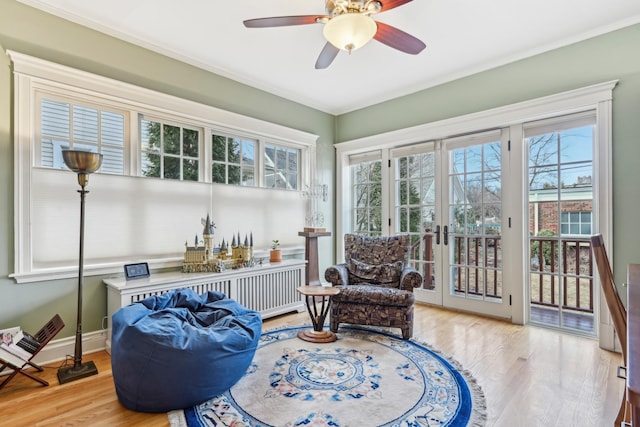 sitting room with ceiling fan, french doors, wood finished floors, and baseboards