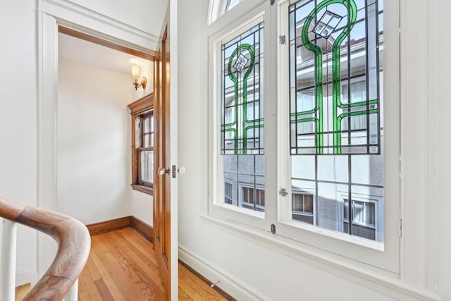 doorway featuring light wood-style floors and baseboards