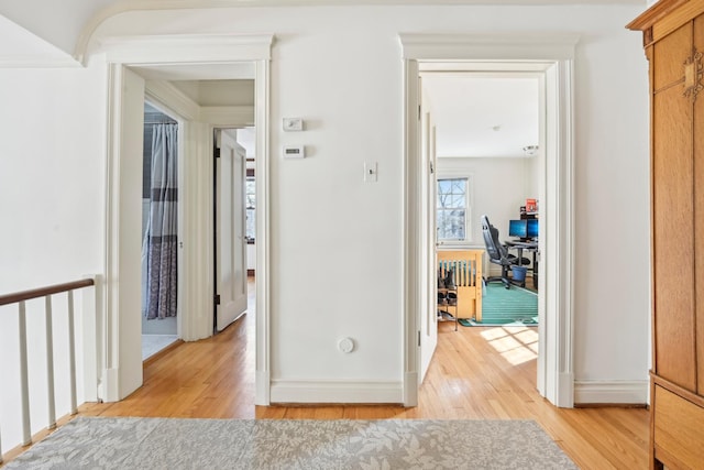 hallway with light wood-style flooring and baseboards