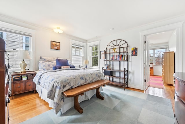 bedroom featuring light wood-type flooring, baseboards, and ornamental molding