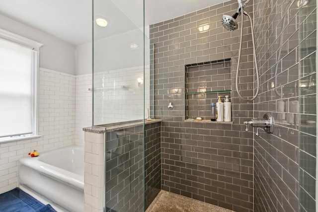 bathroom featuring a garden tub and tiled shower