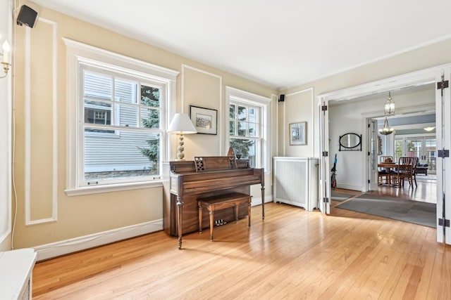 sitting room featuring baseboards, a notable chandelier, and light wood-style floors