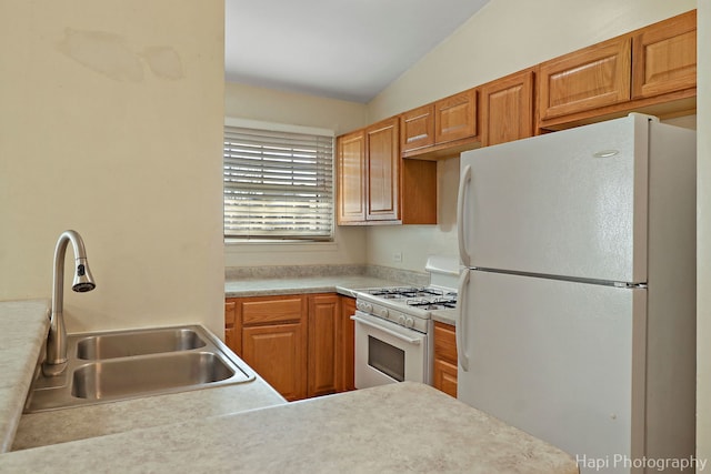 kitchen featuring vaulted ceiling, white appliances, and sink