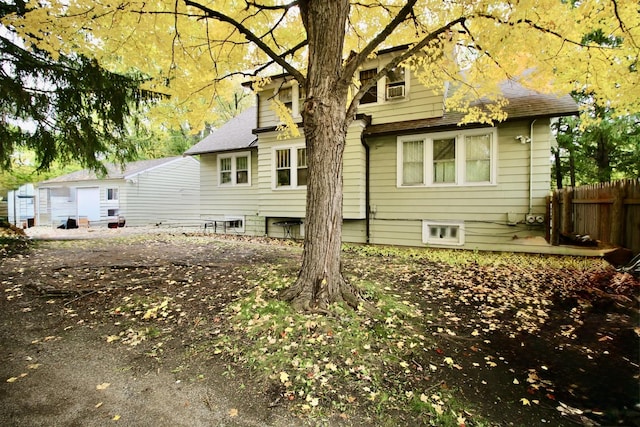 rear view of property with fence and roof with shingles