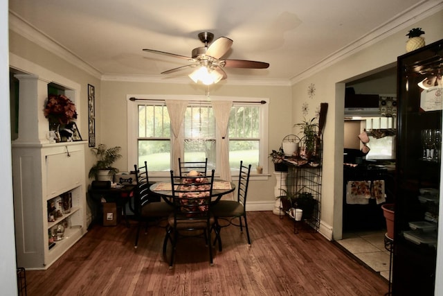 dining room with crown molding, wood finished floors, baseboards, and ceiling fan